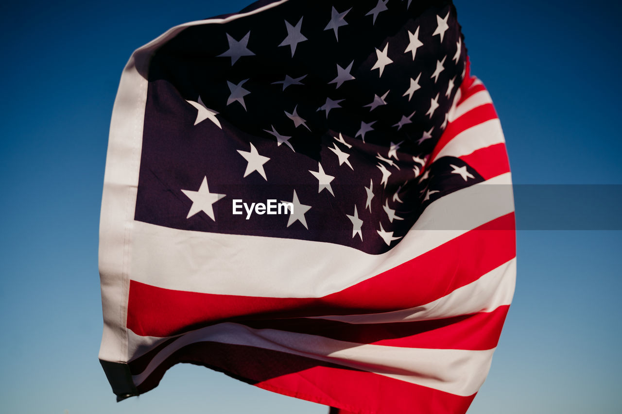 Young woman holding united states flag outdoors at sunset. independence day in america, 4th july