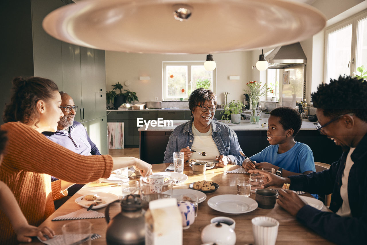 Multiracial family enjoying having food with each other at home