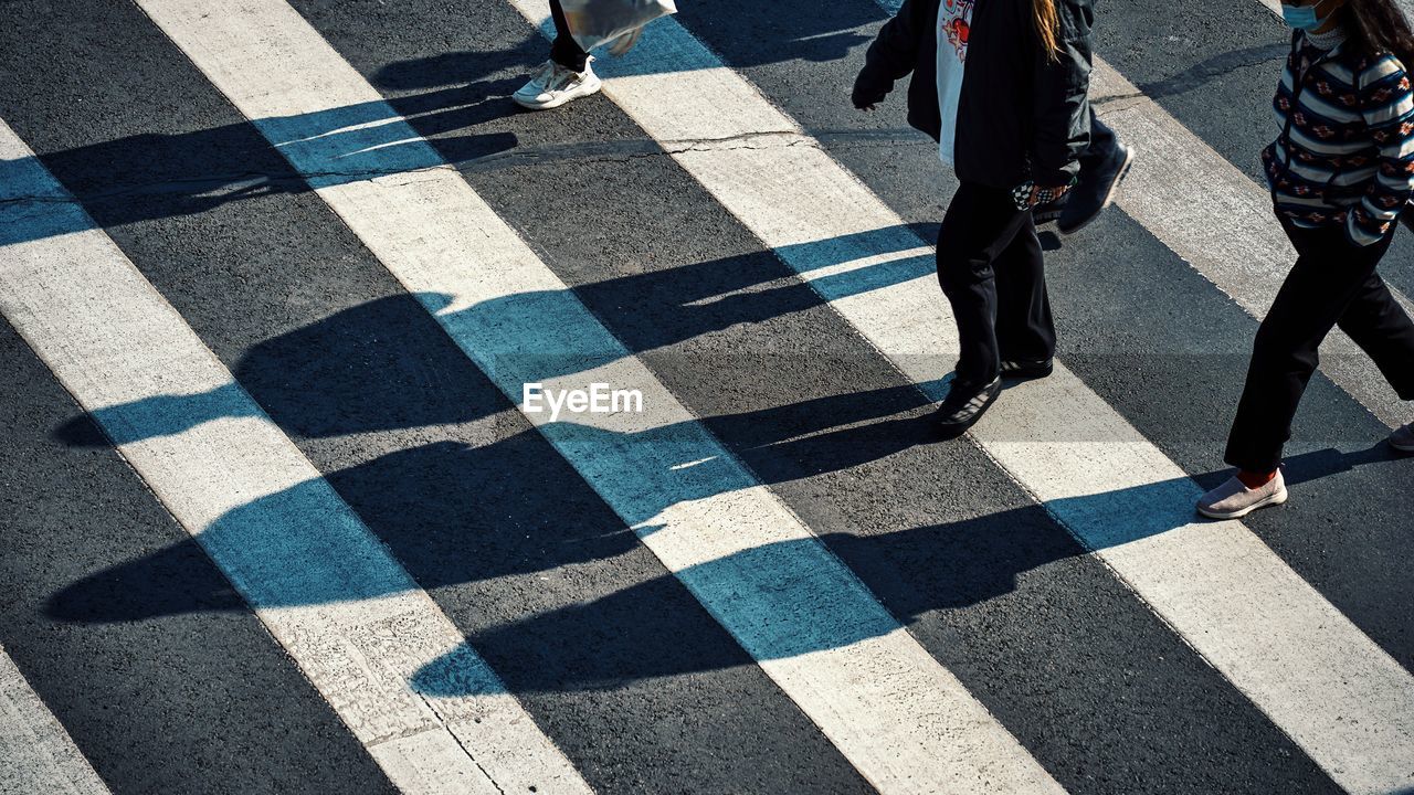 Low section of people walking on street crossing the road