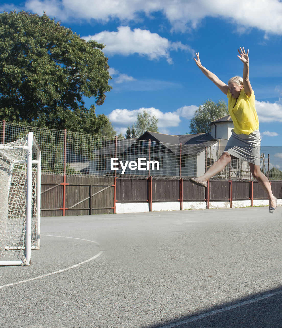 Full length of woman jumping at playing field