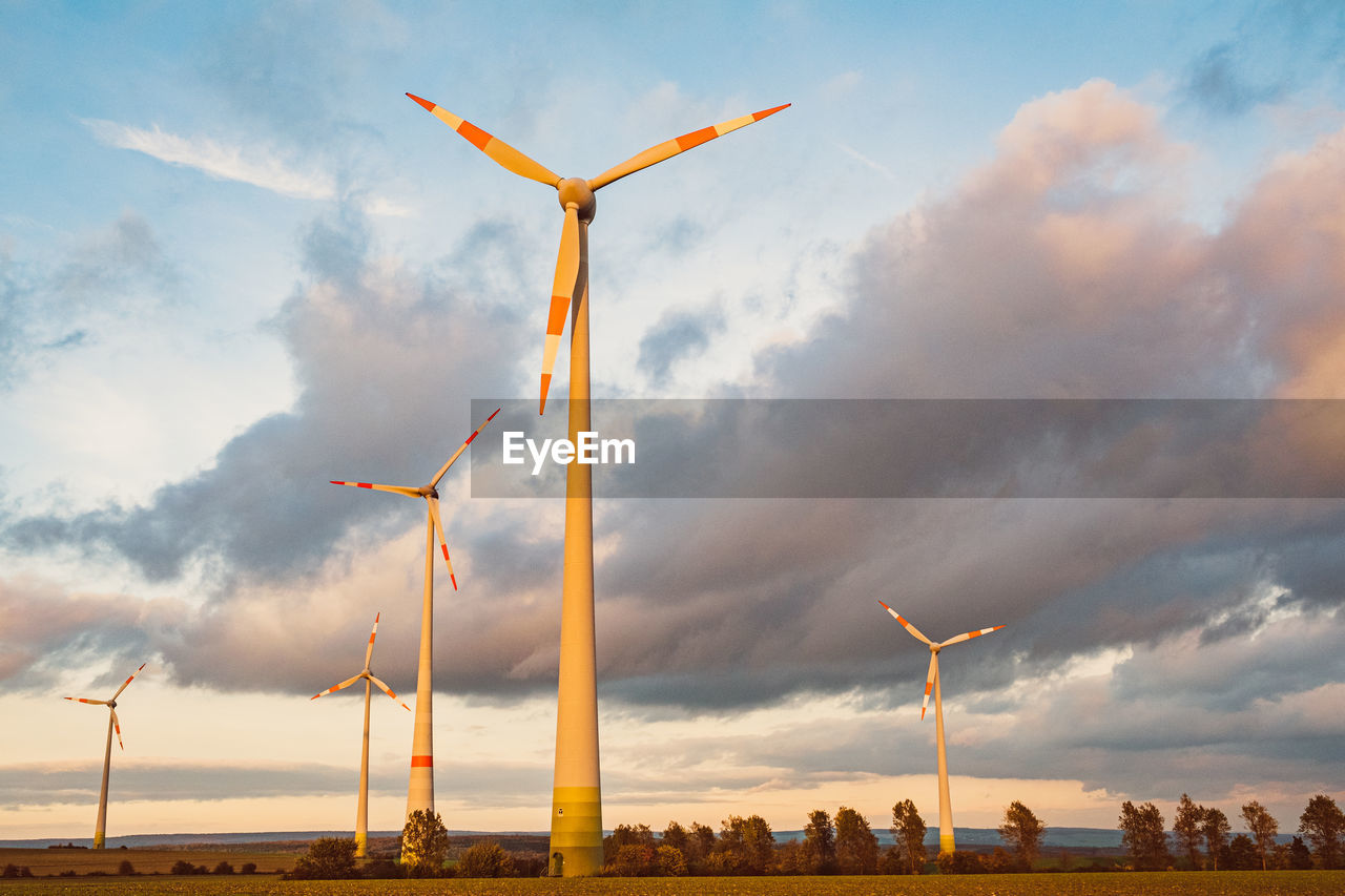 LOW ANGLE VIEW OF WIND TURBINE ON FIELD AGAINST SKY