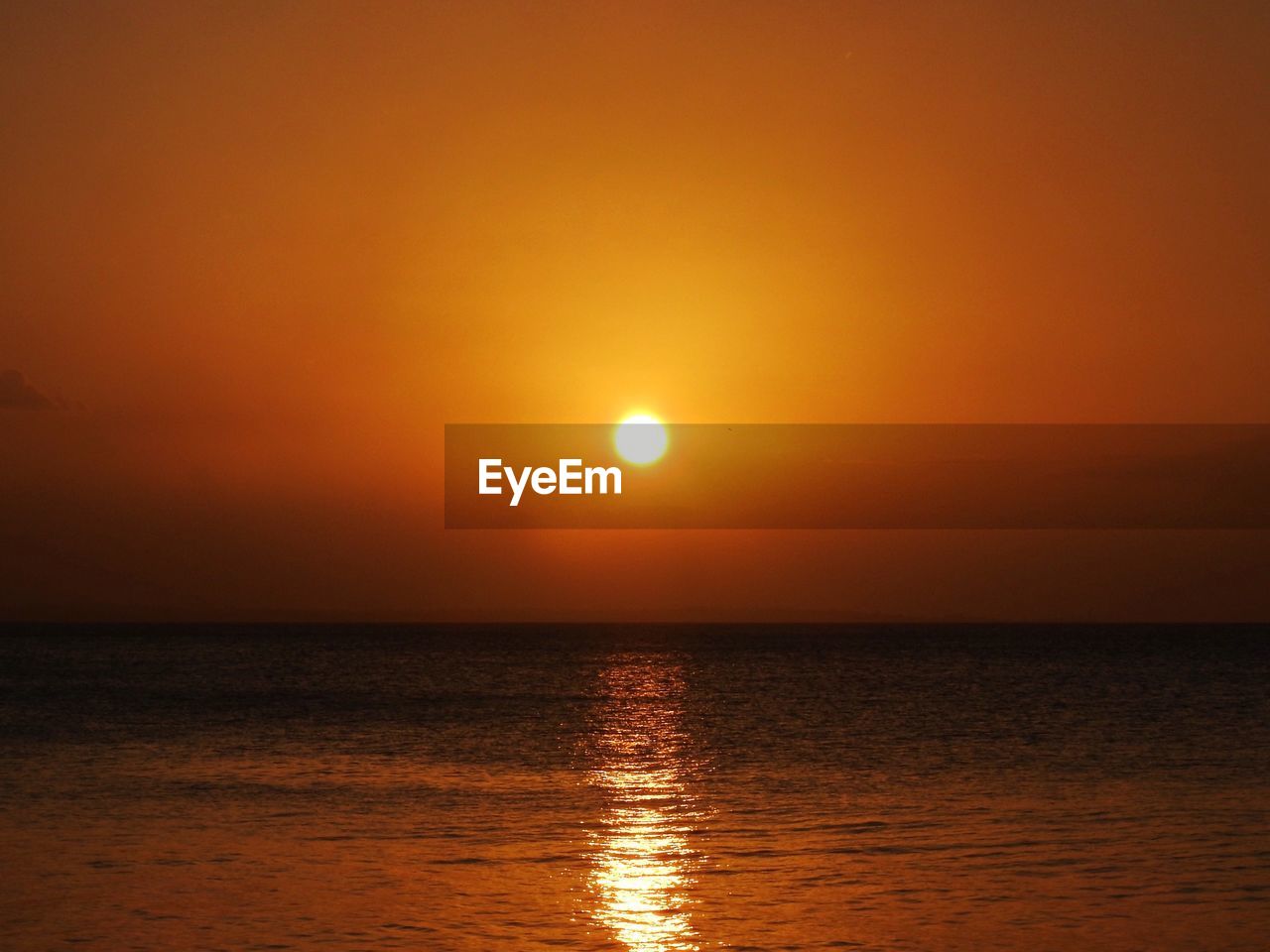 Scenic view of sea against orange sky
