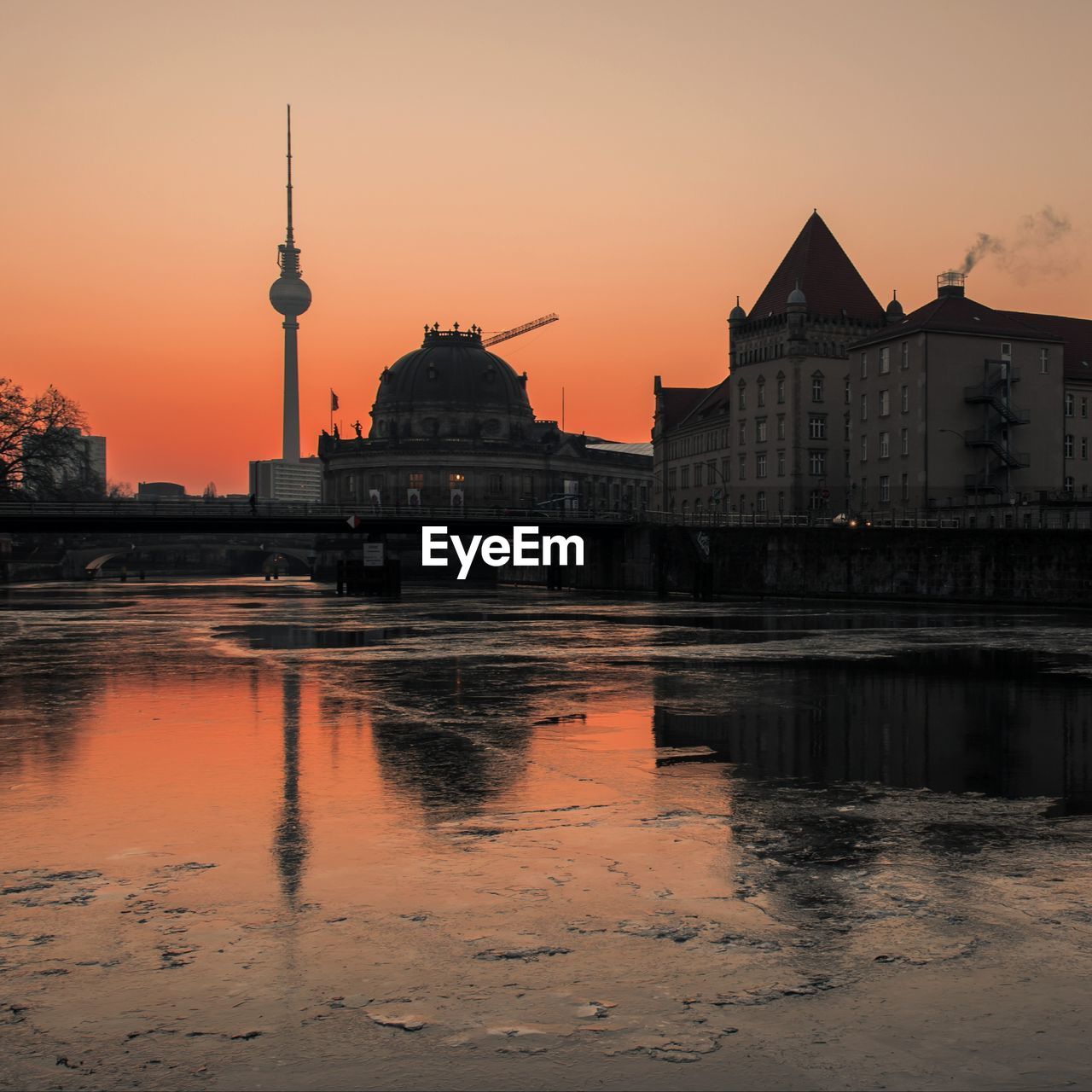 Reflection of buildings in city at sunset