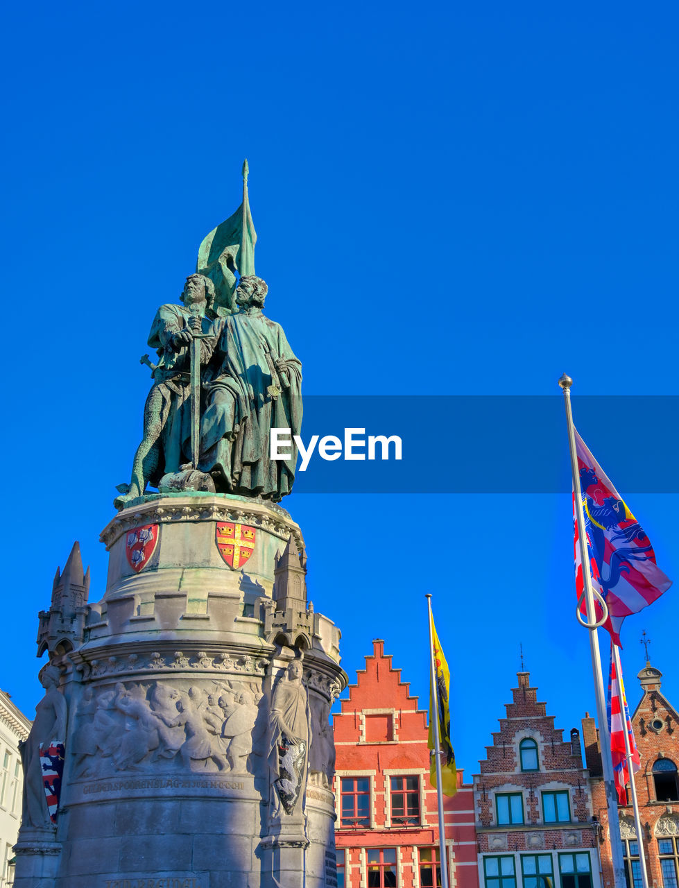 LOW ANGLE VIEW OF STATUE AGAINST BUILDING