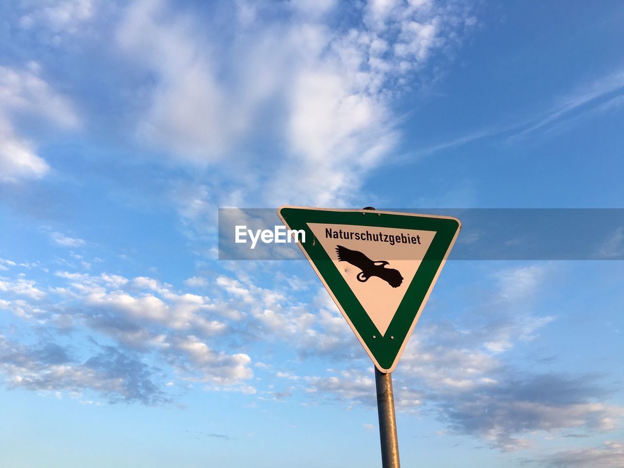 Low angle view of nature reserve signboard against sky