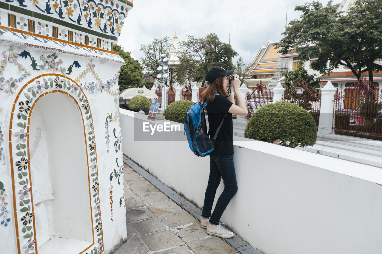 WOMAN PHOTOGRAPHING BUILDING