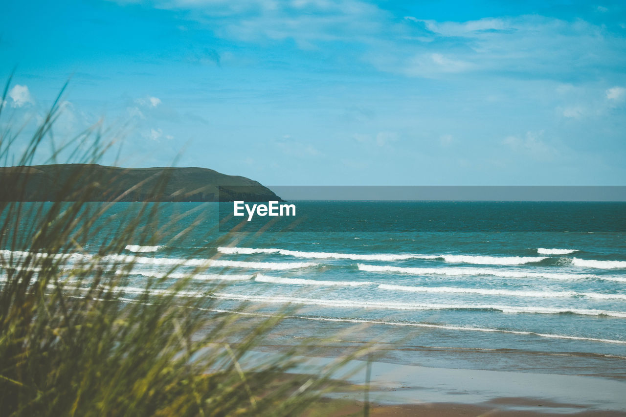 SCENIC VIEW OF BEACH AGAINST BLUE SKY