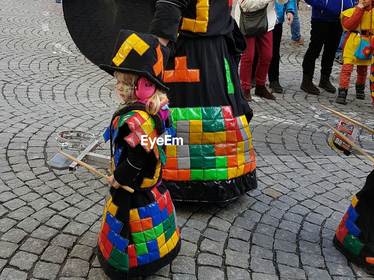 LOW SECTION OF MEN STANDING ON MULTI COLORED UMBRELLA