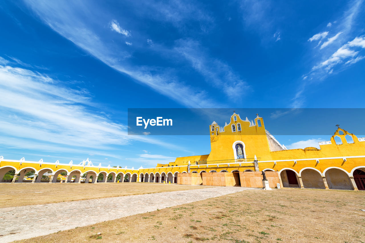 Low angle view of yellow monastery against sky
