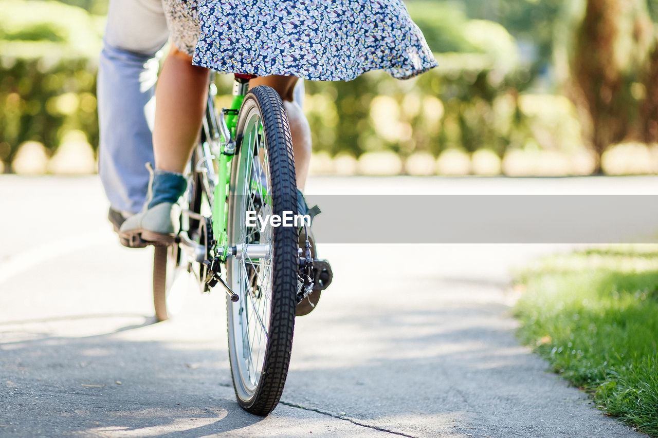 Low section of couple cycling on road