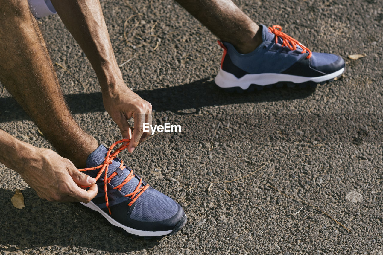 Close up of male athlete tying sport shoes shoelaces