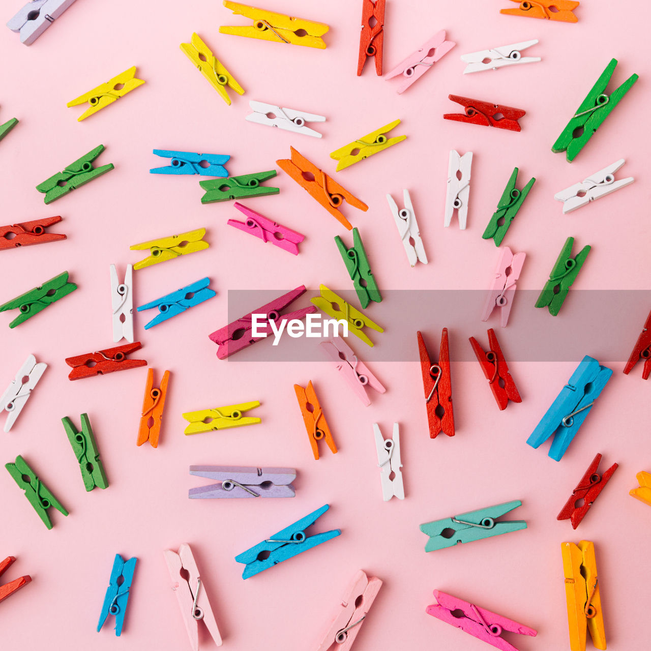 High angle view of multi colored clothespin on colored background