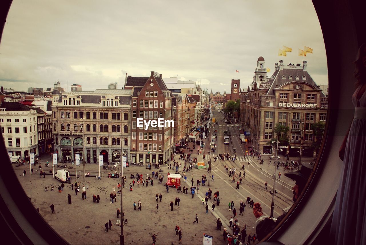 People on street in city seen through window