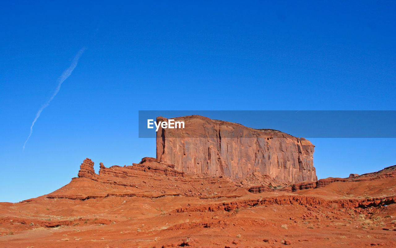 Rock formations on landscape against clear blue sky