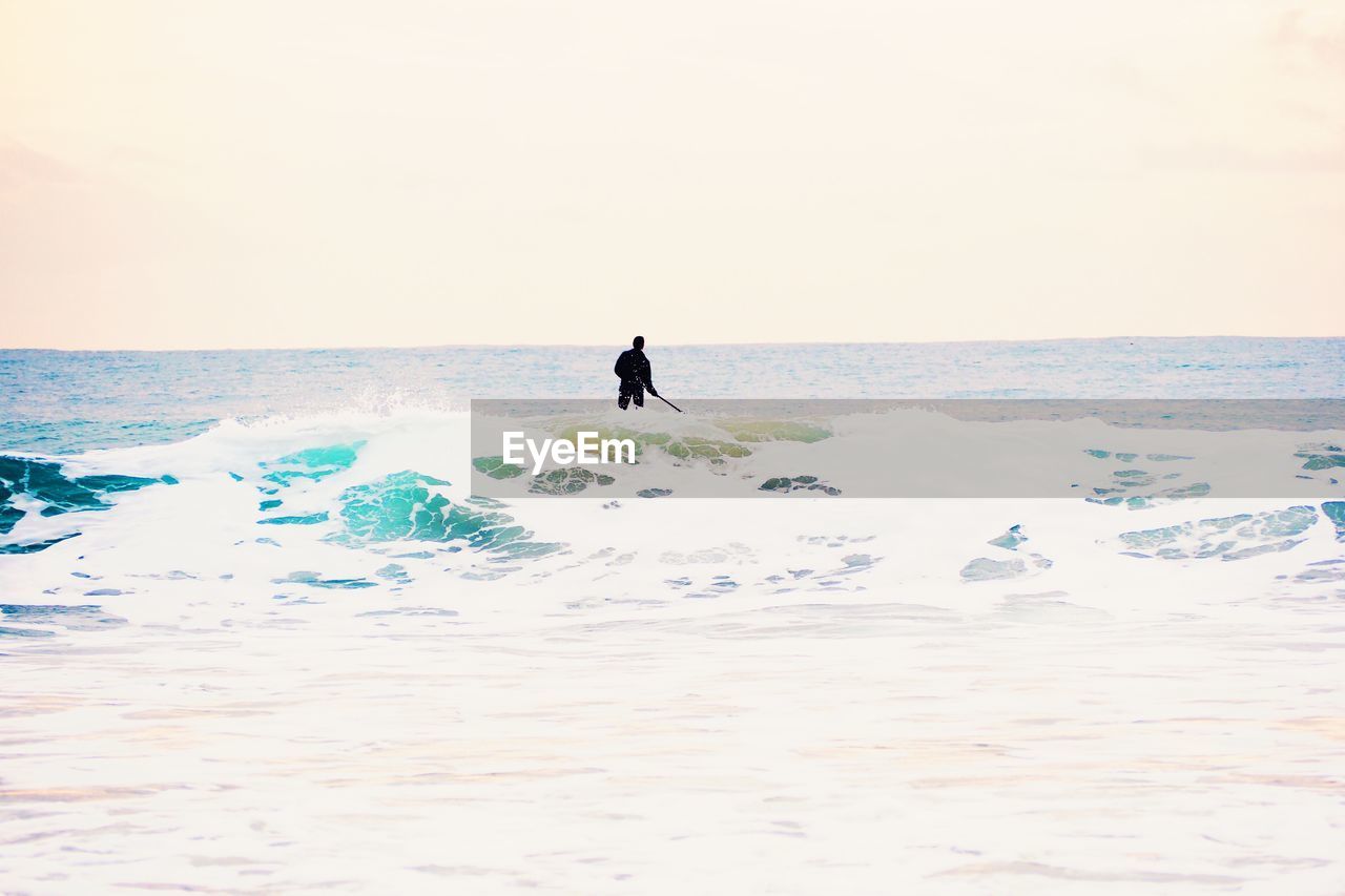 Man paddleboarding in sea