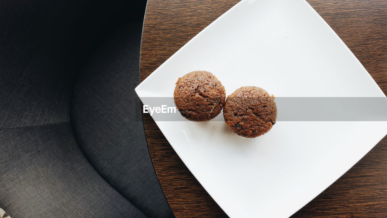 High angle view of cupcakes in plate on wooden table