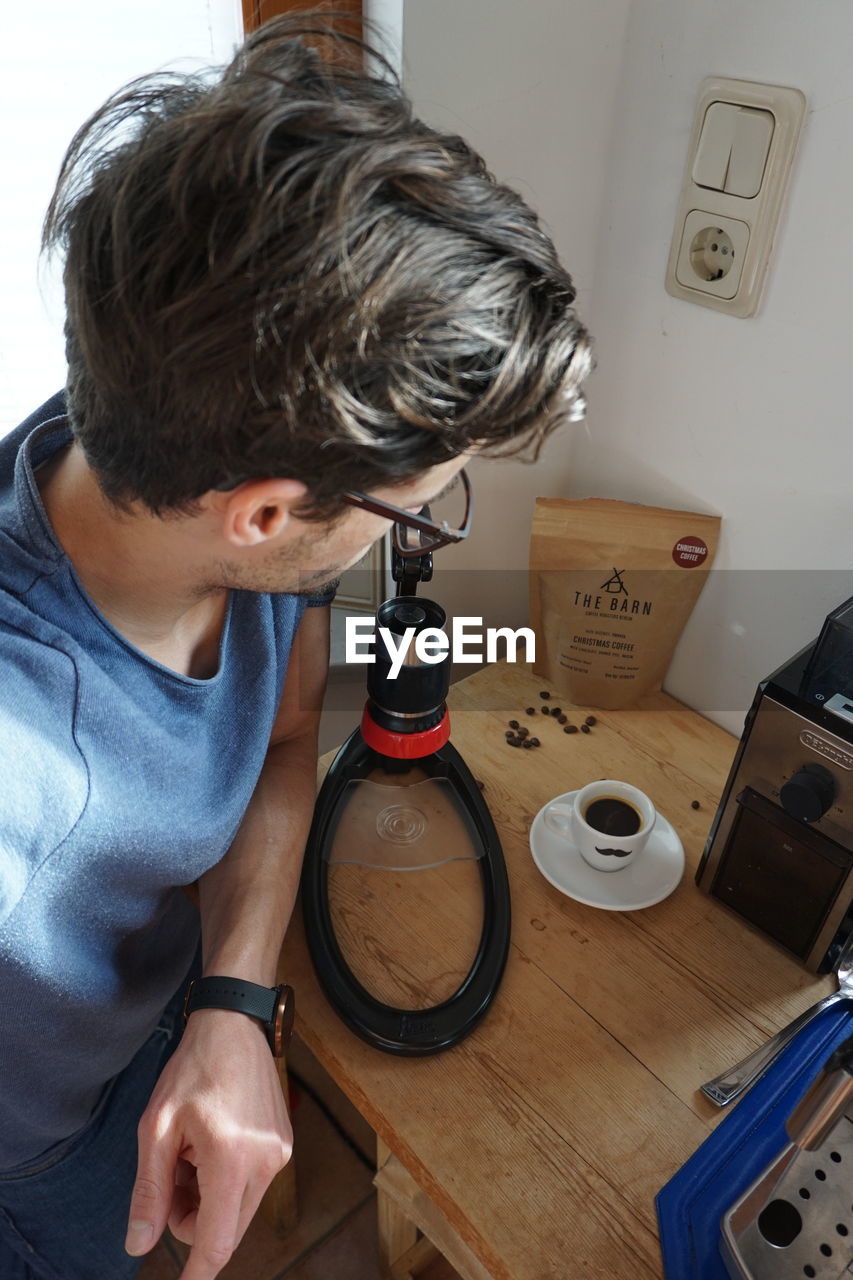 MAN AND COFFEE CUP ON TABLE