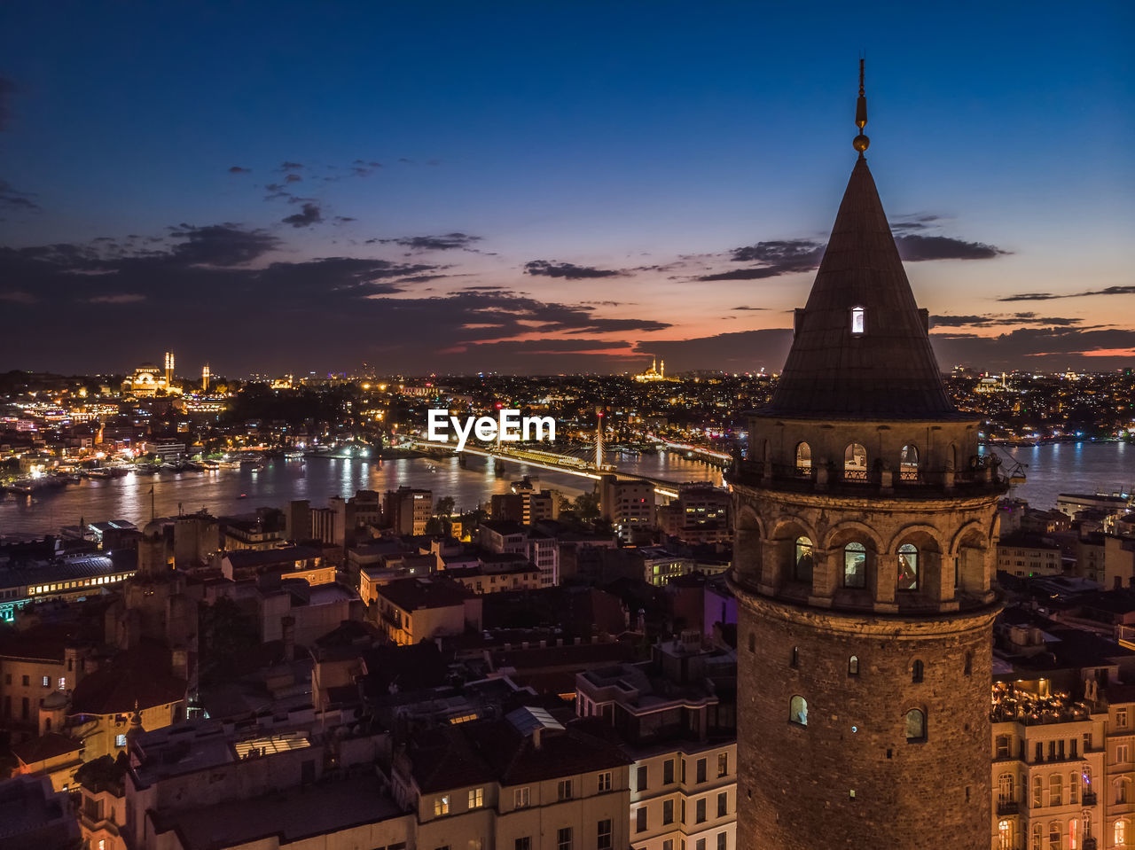 ILLUMINATED CITYSCAPE AGAINST SKY