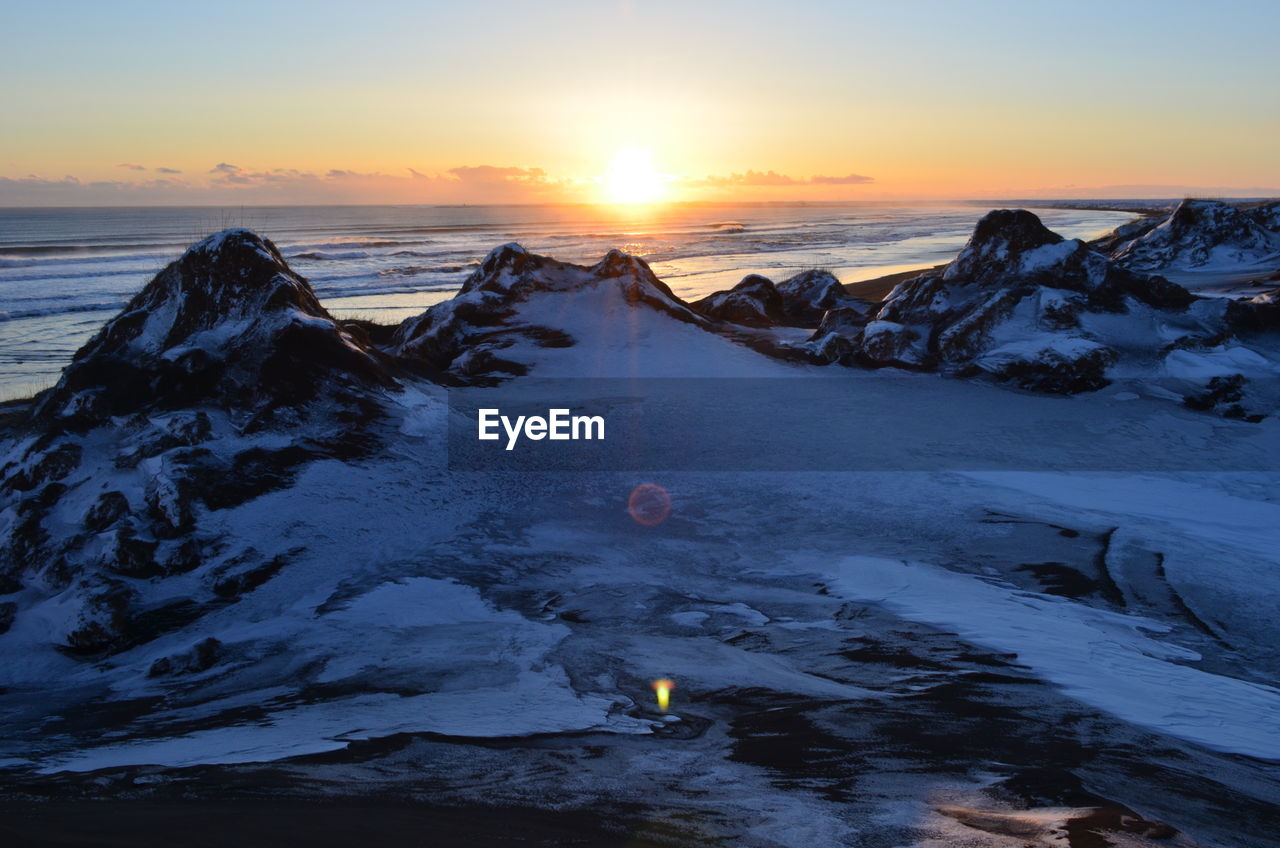 Scenic view of frozen sea against sky during sunset