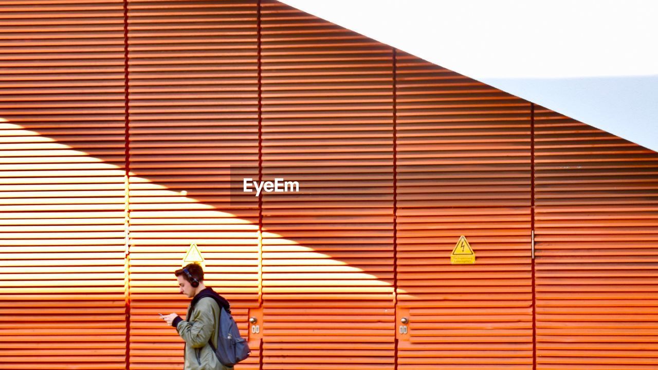 WOMAN STANDING AGAINST BUILDING