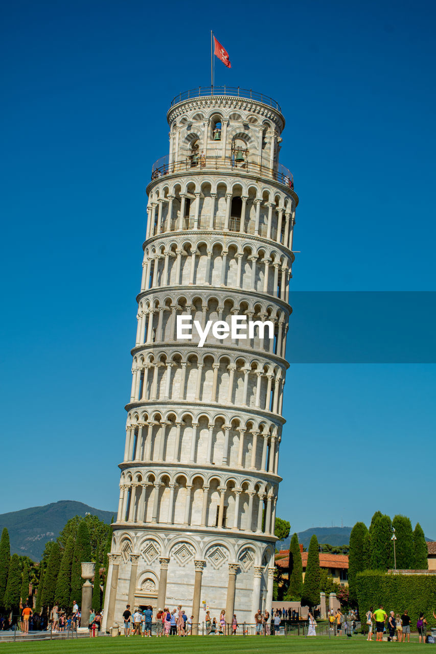 Low angle view of leaning tower against clear blue sky