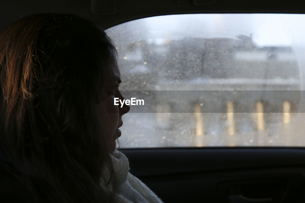 Portrait of woman seen through car window