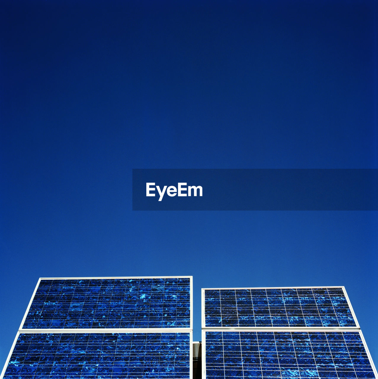 Low angle view of solar panels against clear blue sky