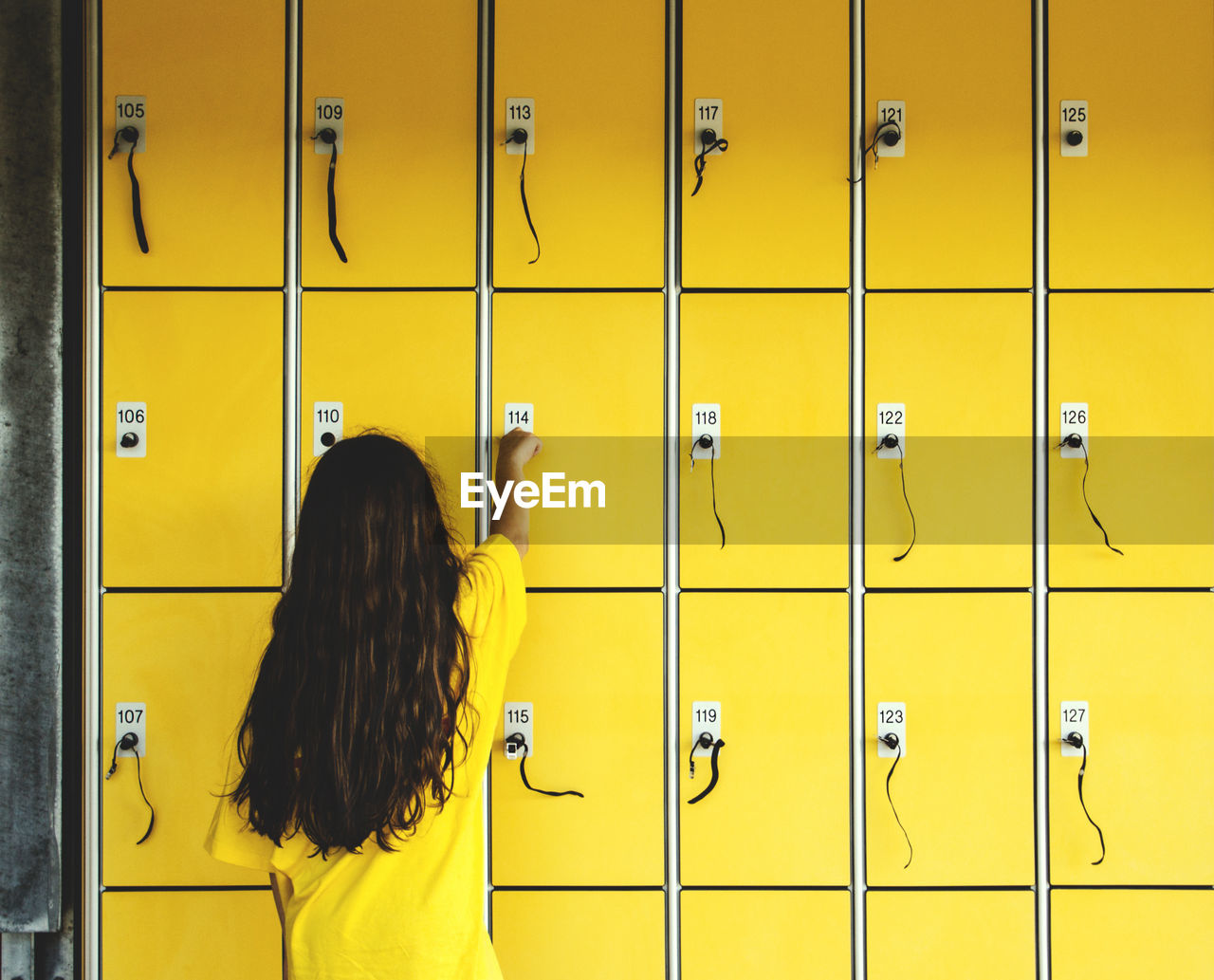 Rear view of girl using locker