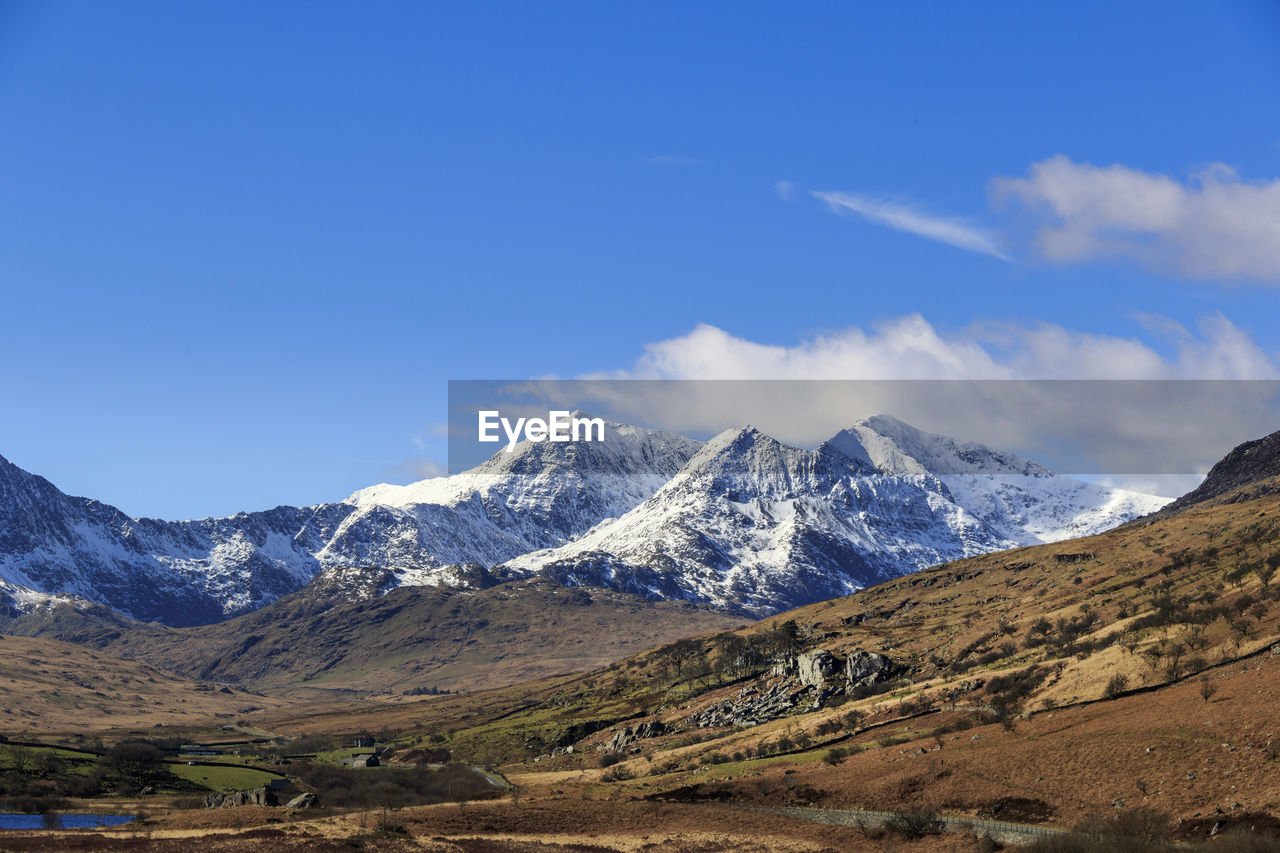 scenic view of snowcapped mountains against blue sky