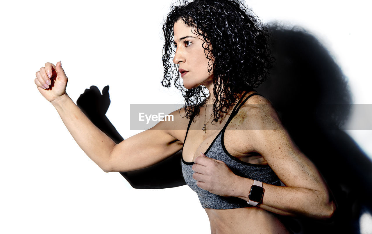Portrait of a athletic woman moving against white background