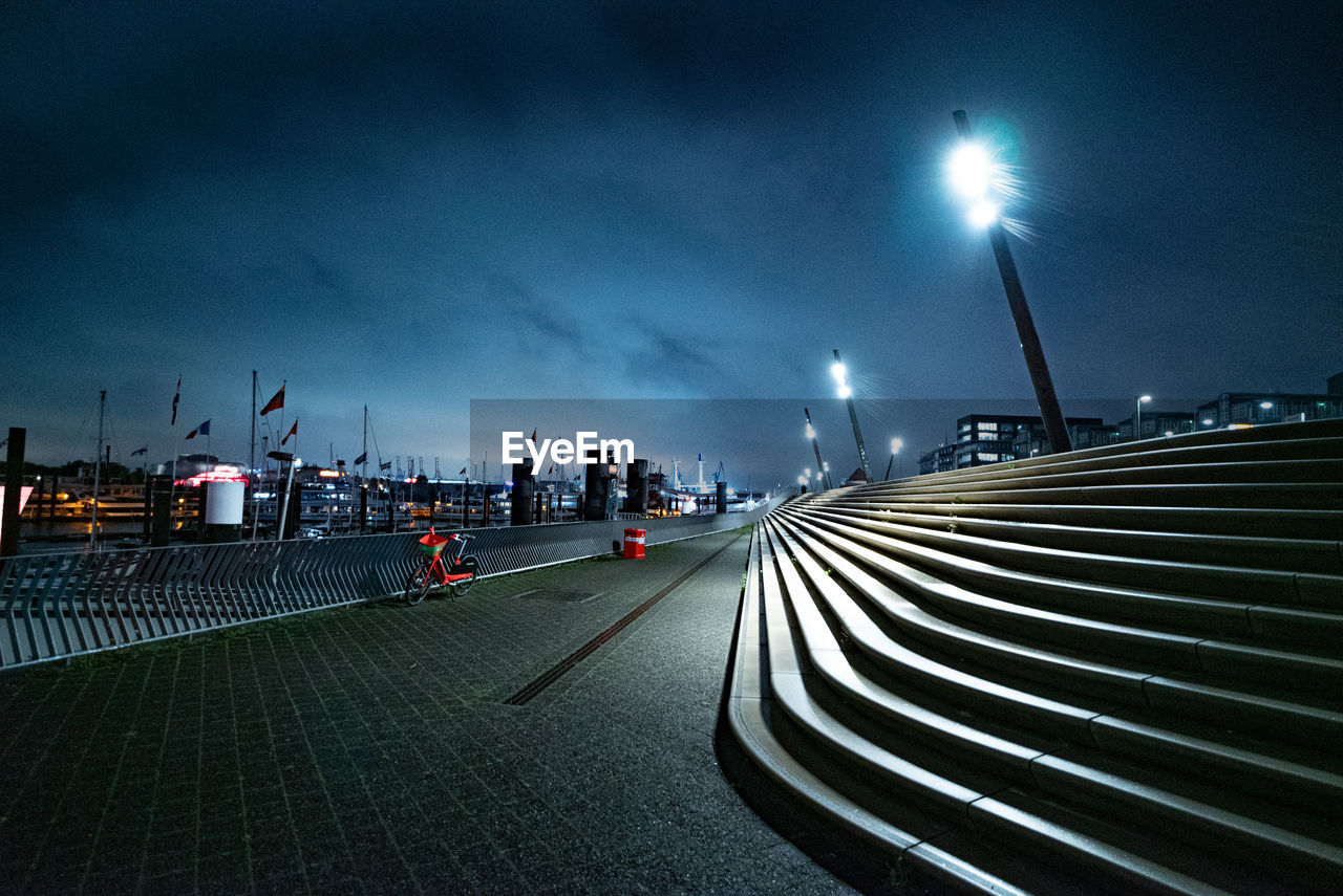 people walking on street against sky at night