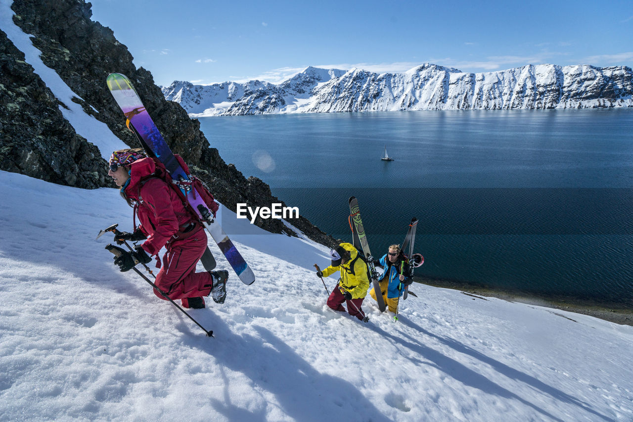 Group of friends skinning up mountain to ski in svalbard