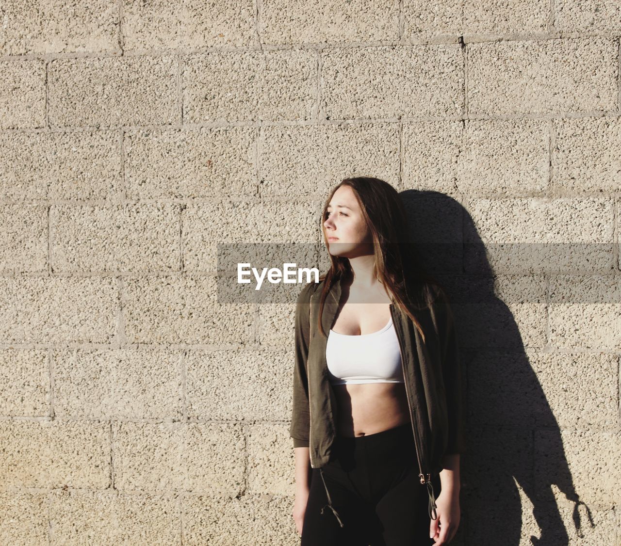 PORTRAIT OF YOUNG WOMAN STANDING OUTDOORS