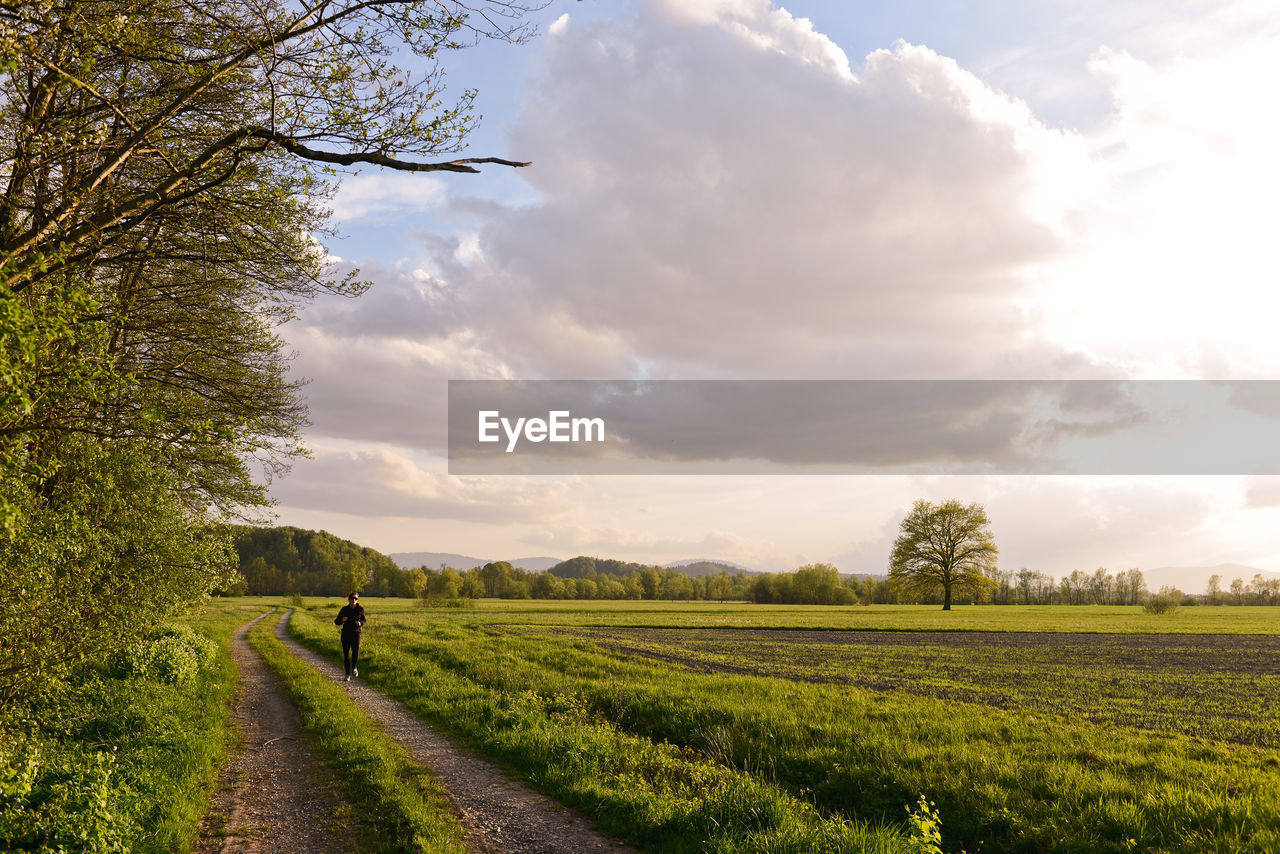 VIEW OF FIELD AGAINST CLOUDY SKY