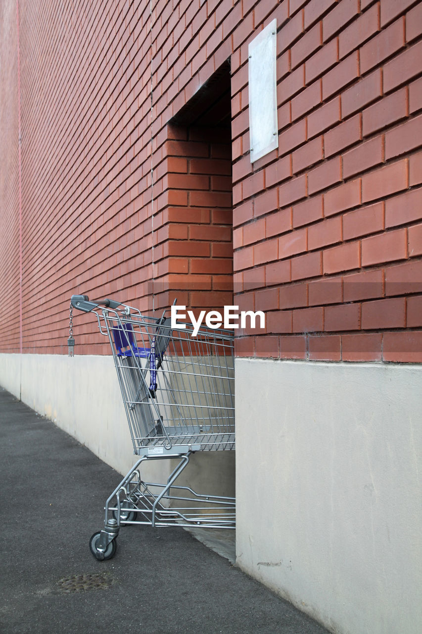 Shopping cart against brick wall