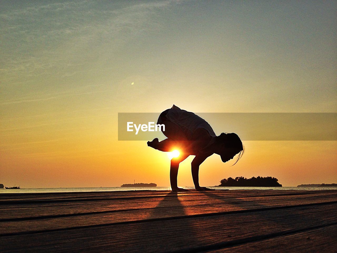 Woman practicing yoga on the beach