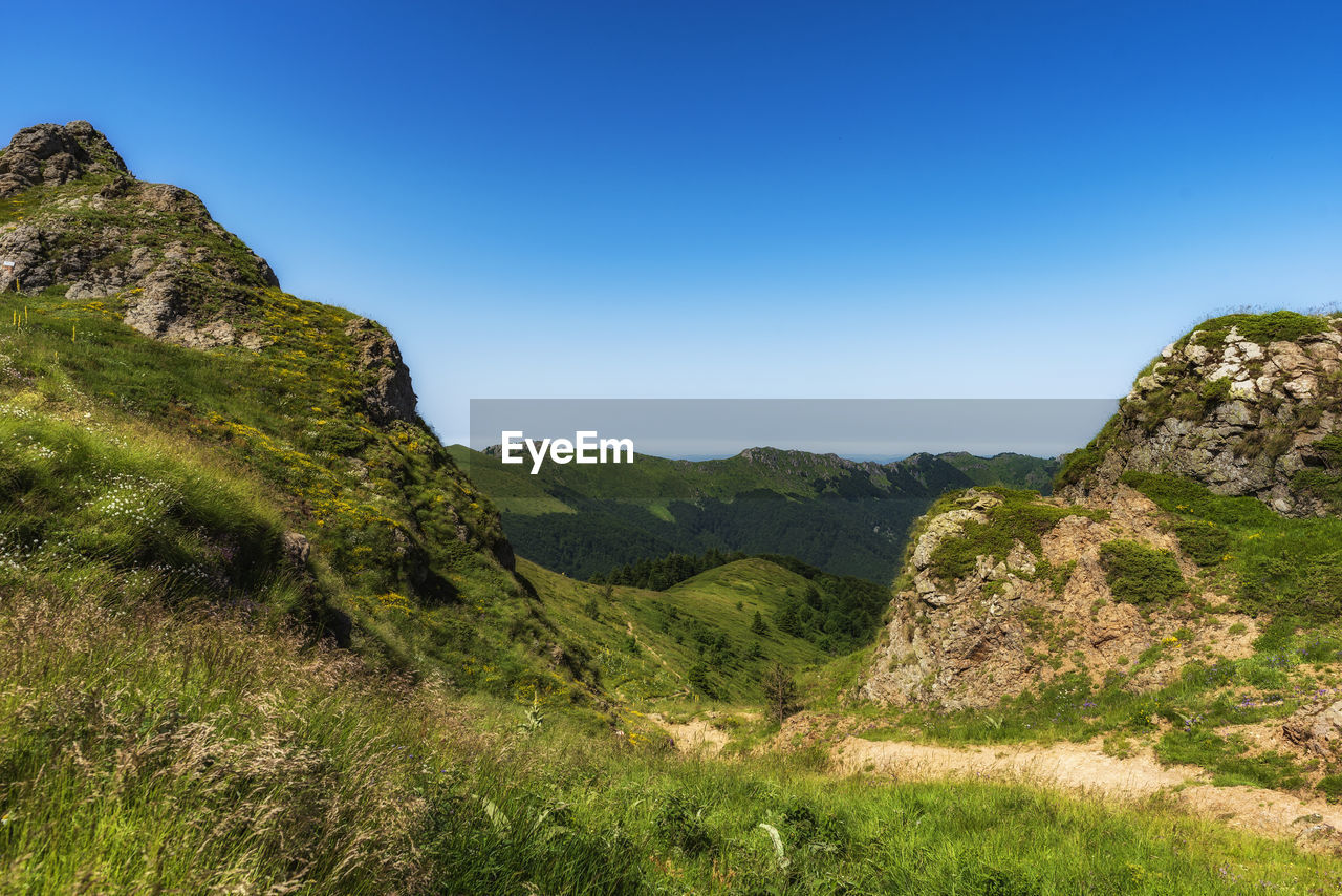 SCENIC VIEW OF MOUNTAIN AGAINST BLUE SKY