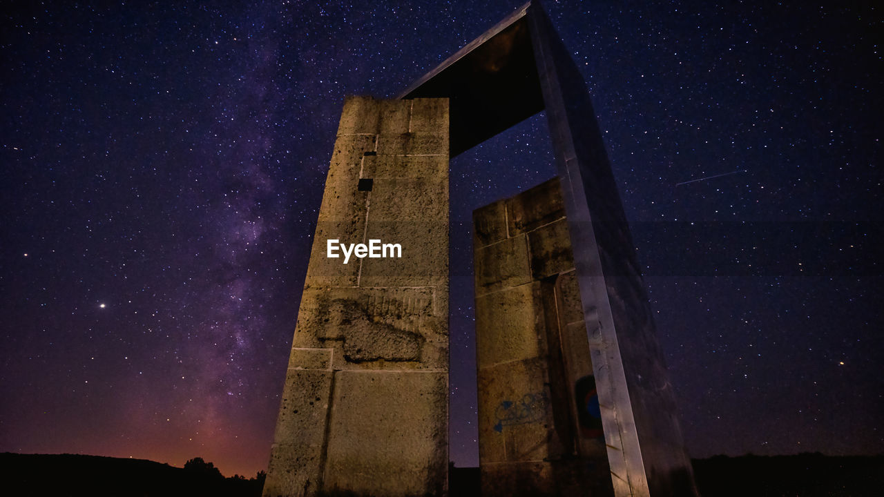 Low angle view of abandoned building against sky at night