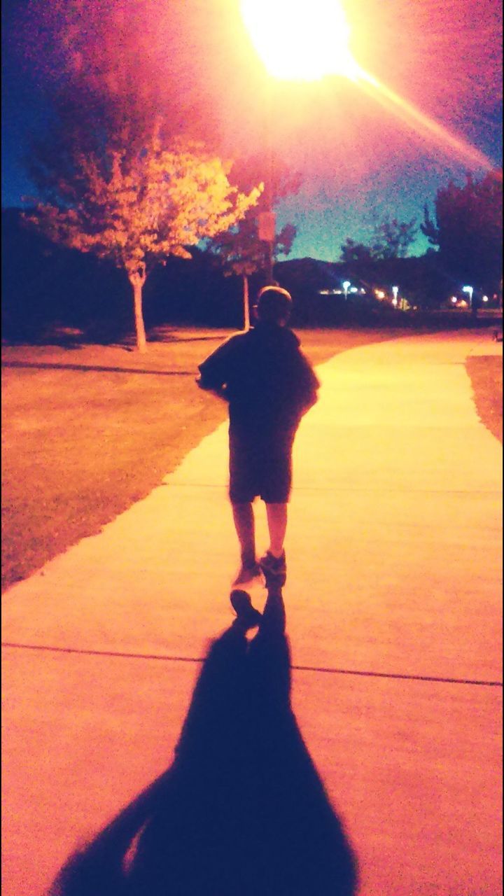 SHADOW OF PEOPLE WALKING ON ROAD