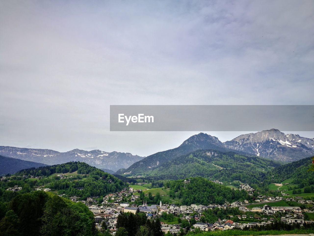 Scenic view of townscape and mountains against sky