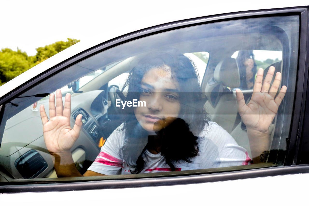 Portrait of woman looking through car window