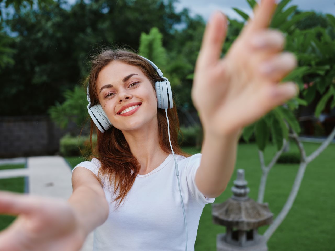 portrait of smiling young woman with eyes closed against trees