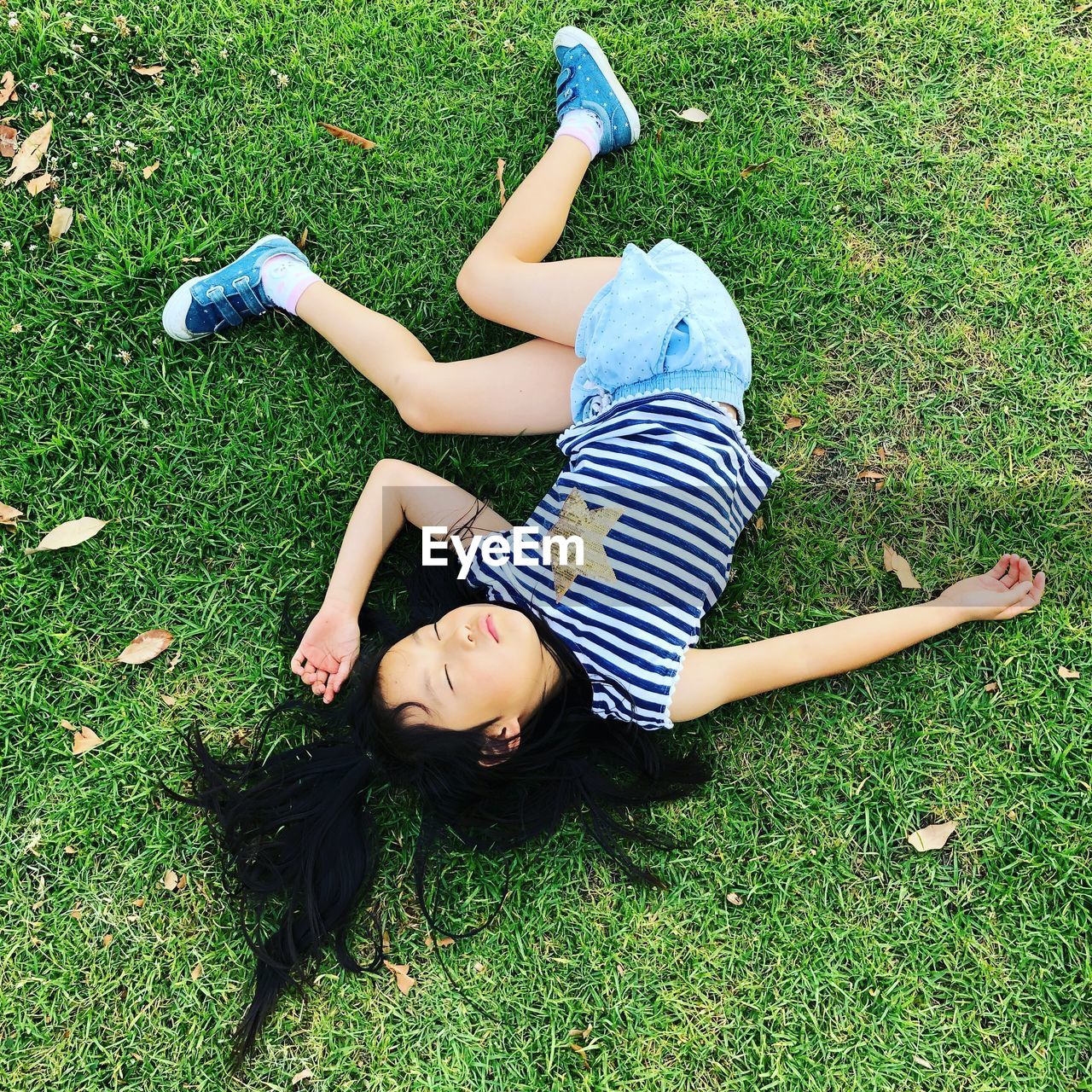 High angle view of girl lying on grassy field