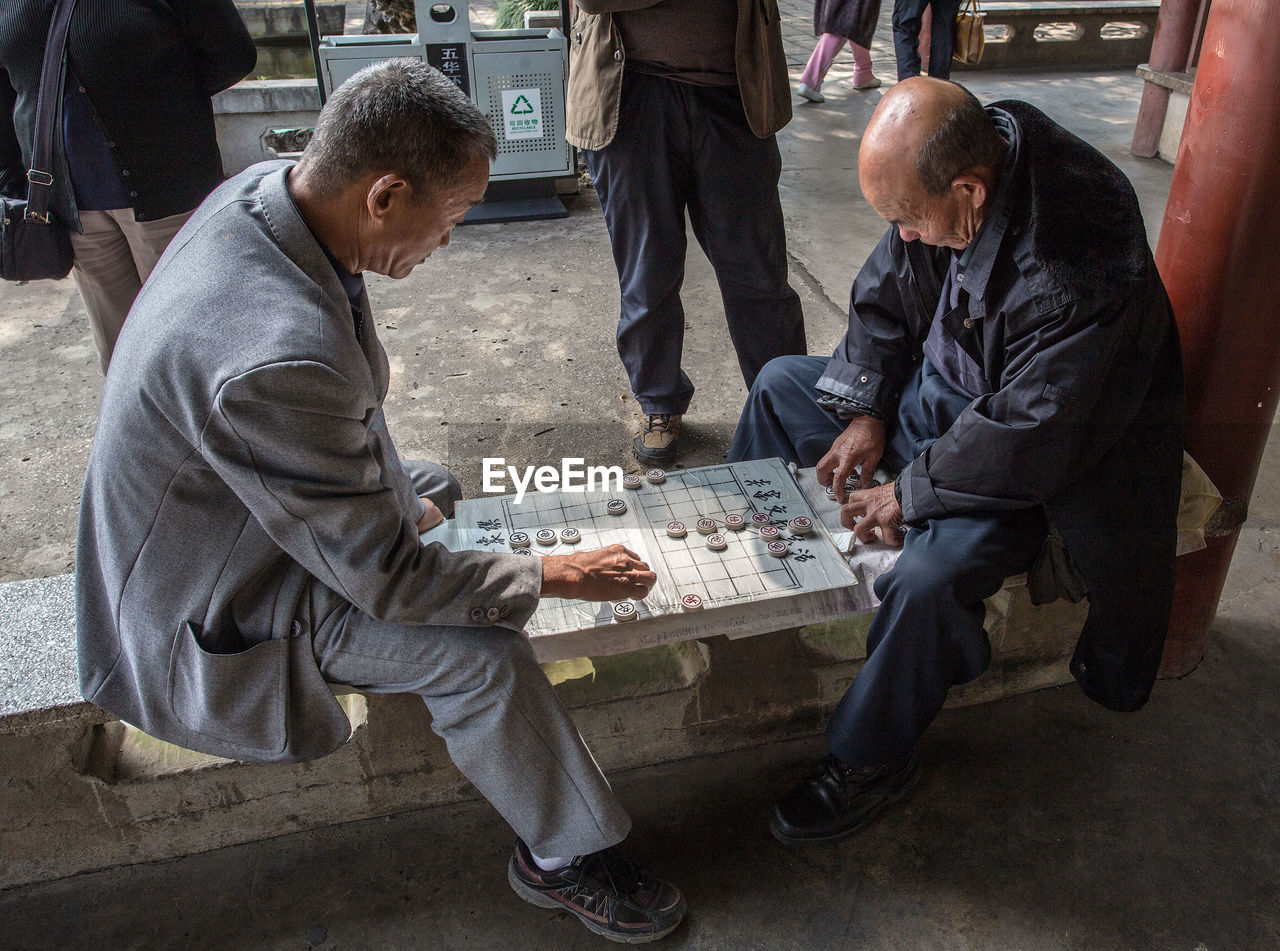 MEN SITTING ON STREET