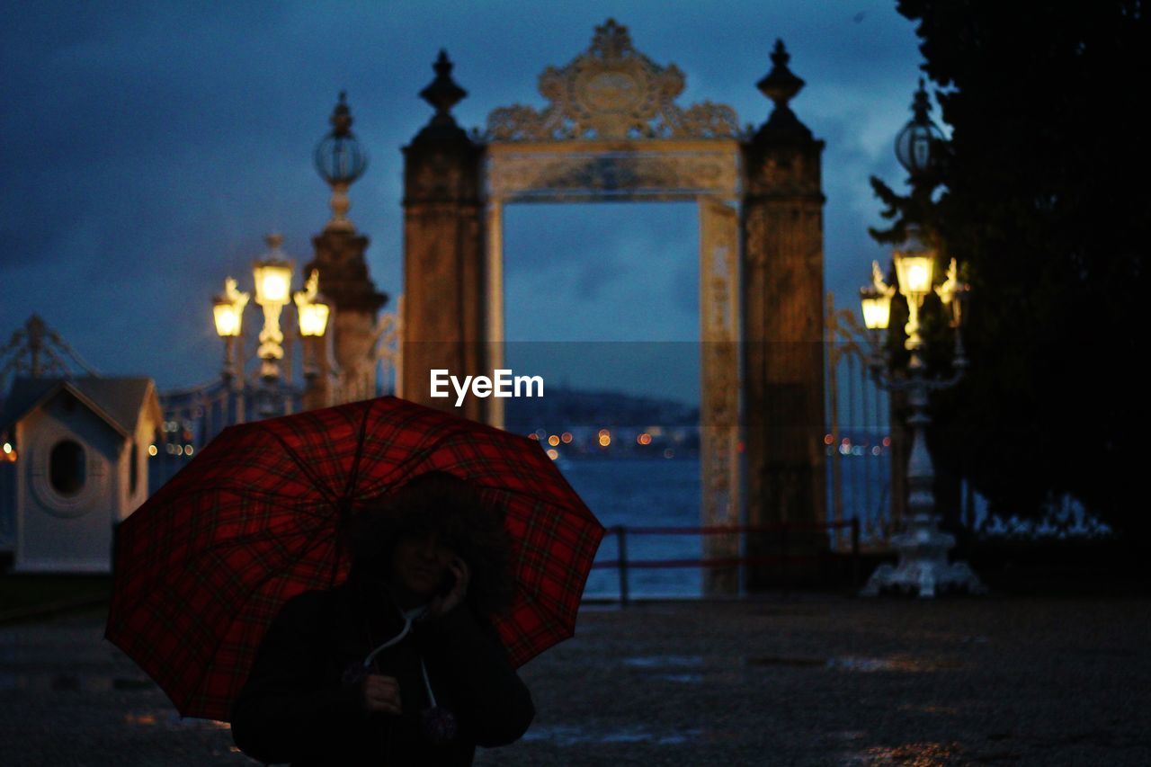 Person with umbrella during rain at dusk