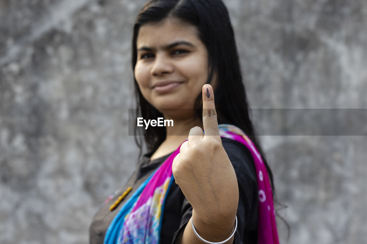 Selective focus on ink-marked finger of an indian woman with smiling face