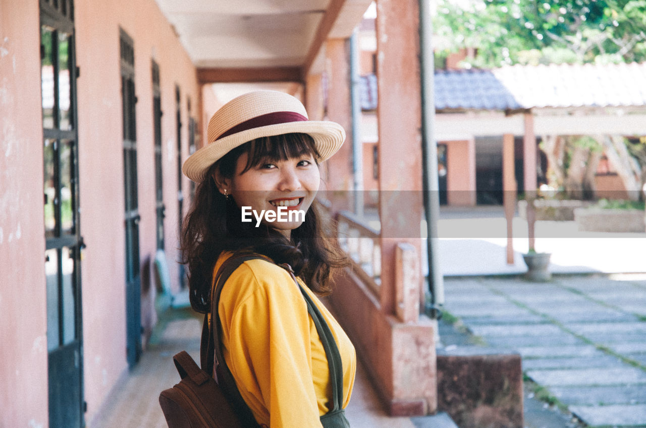 Portrait of smiling young woman in sun hat 