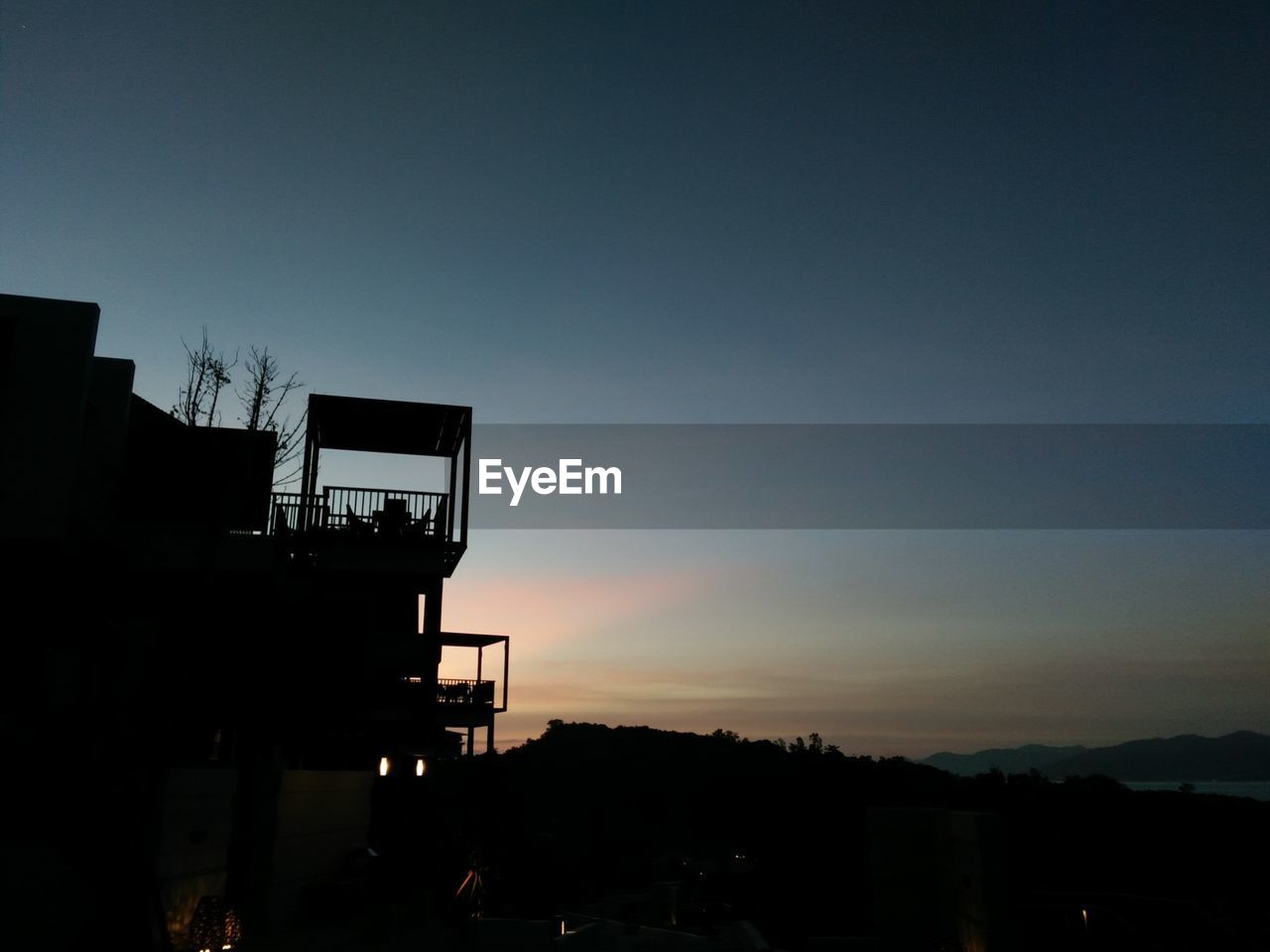 SILHOUETTE OF BUILDING AGAINST SKY AT SUNSET