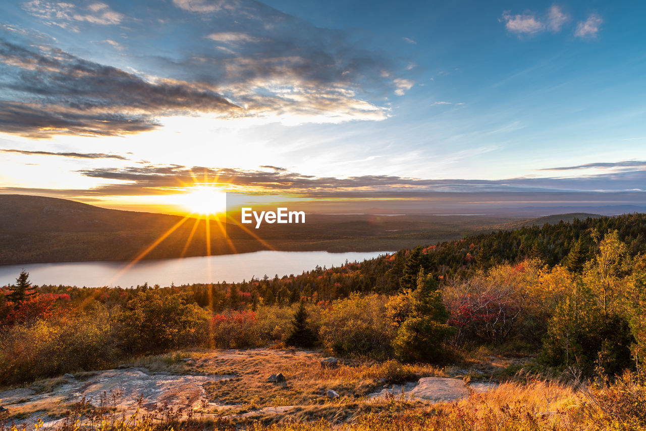 Scenic view of lake amidst landscape against sky during sunset