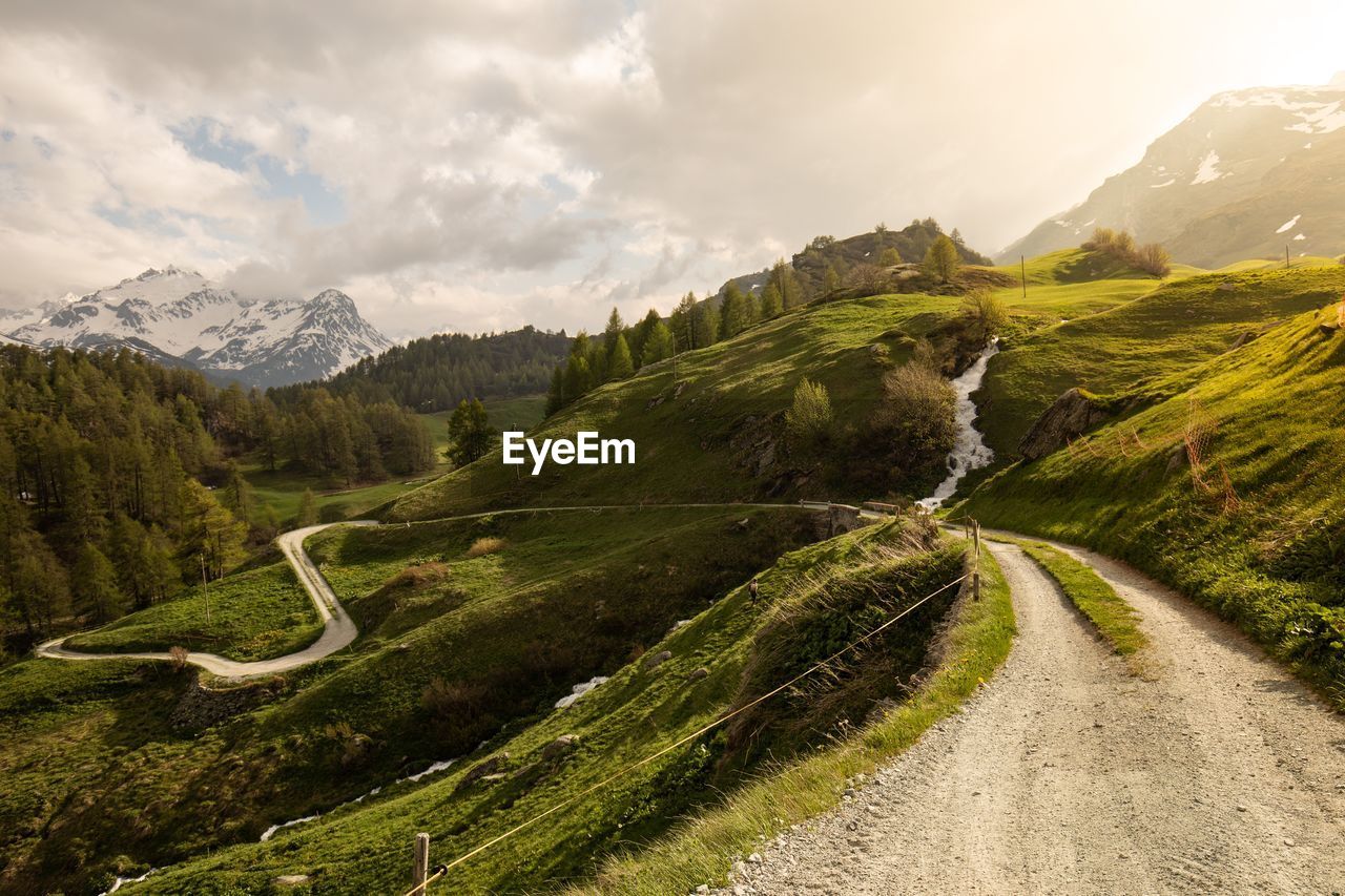 Scenic view of road amidst mountains against sky